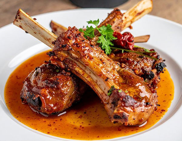 Wood-fired lamb ribs with harissa honey glaze
